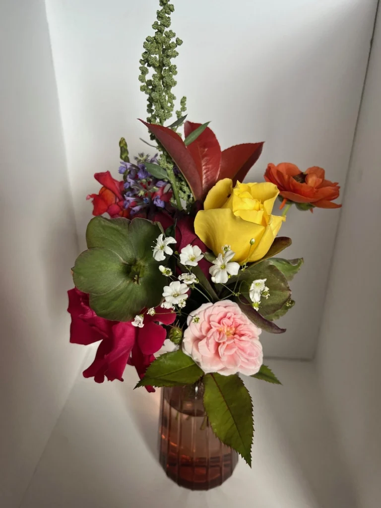 A small flower bouquet with a rose in it.
